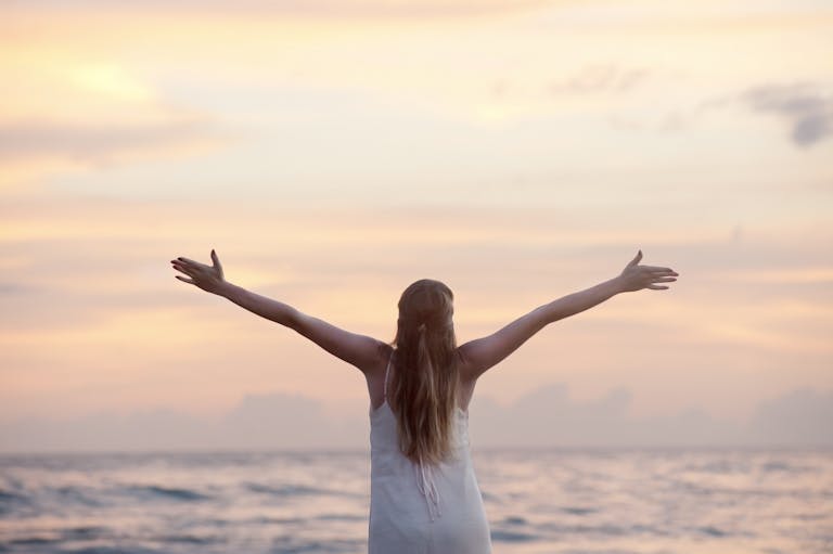 A woman enjoying a serene sunset on Unawatuna Beach, Sri Lanka, depicting peace and freedom.